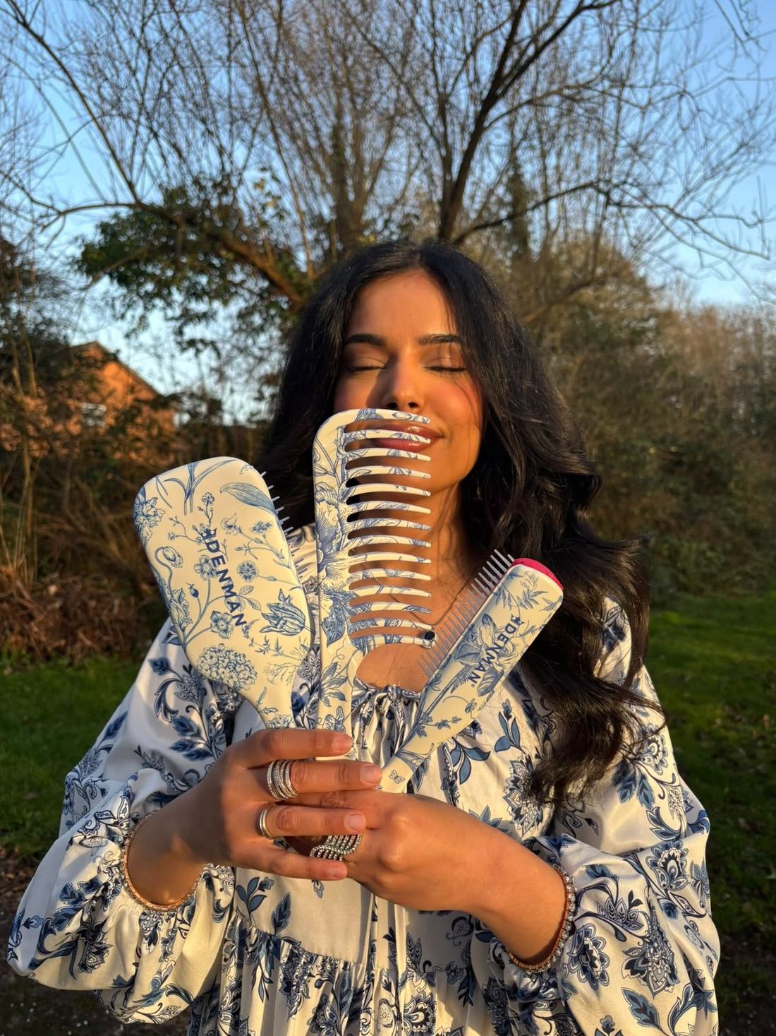 Simrah outdoors holding her brushes and combs