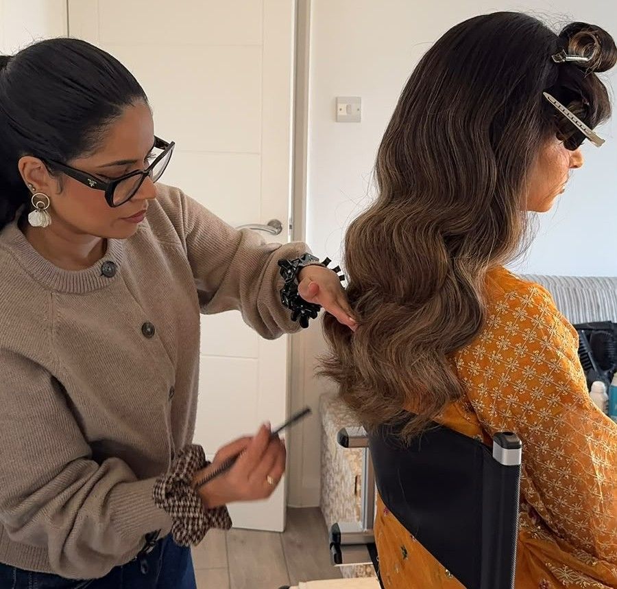 Simrah brushing out a client's waves at a home appointment