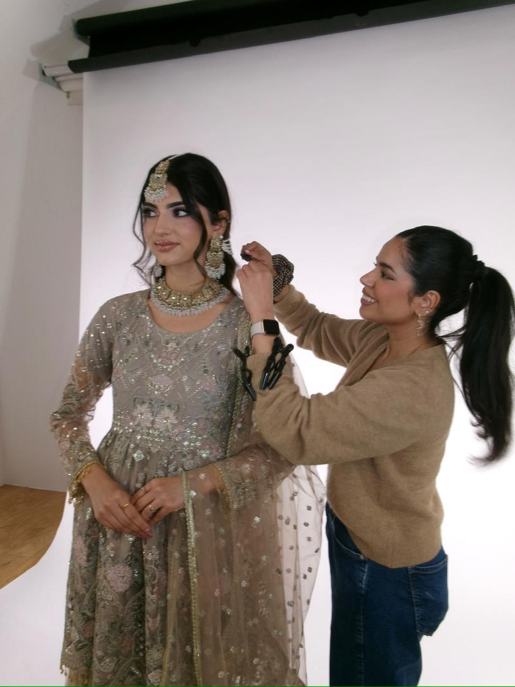 Simrah styling a model on a white studio backdrop