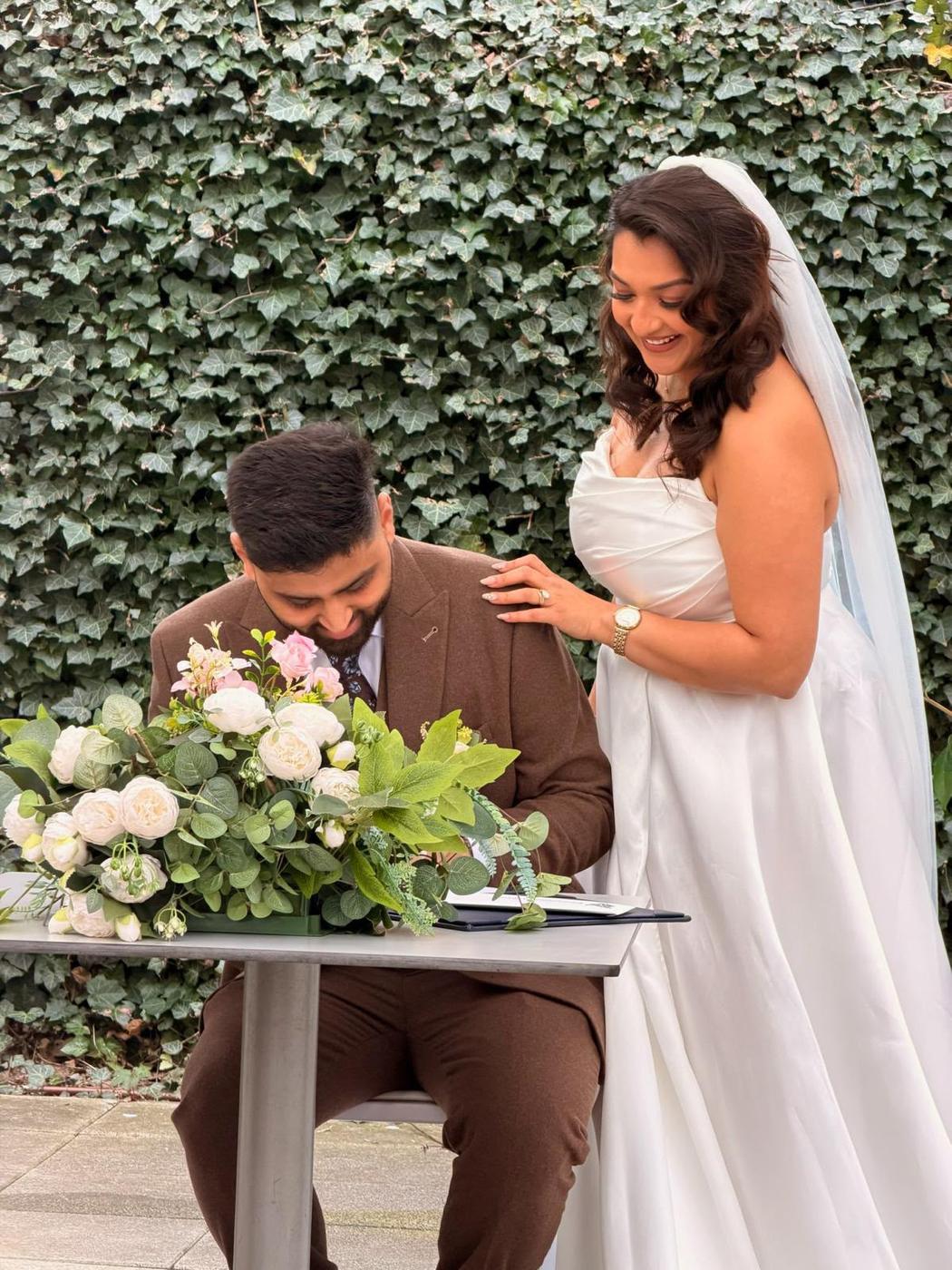 Bride signing the register outdoors with soft waves worn down