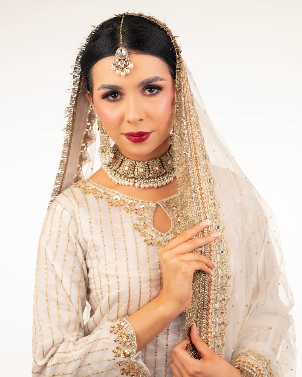 Sleek centre-parted style worn under a gold-edged dupatta