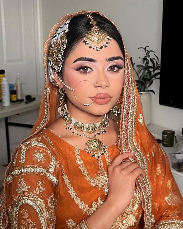 Mehndi bride with a pearl side piece and gold tikka set into the hair