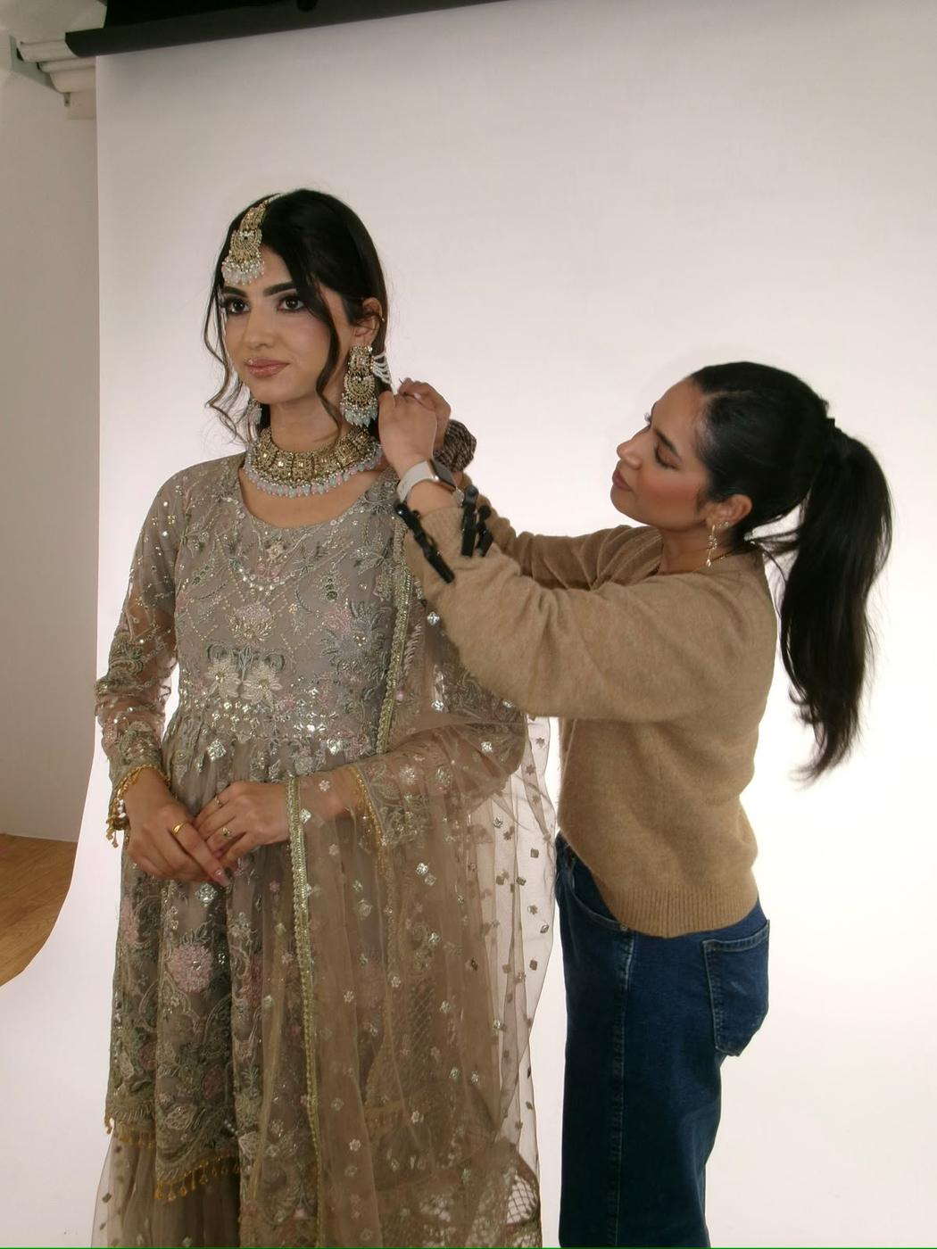 Simrah setting a model's dupatta during a studio shoot